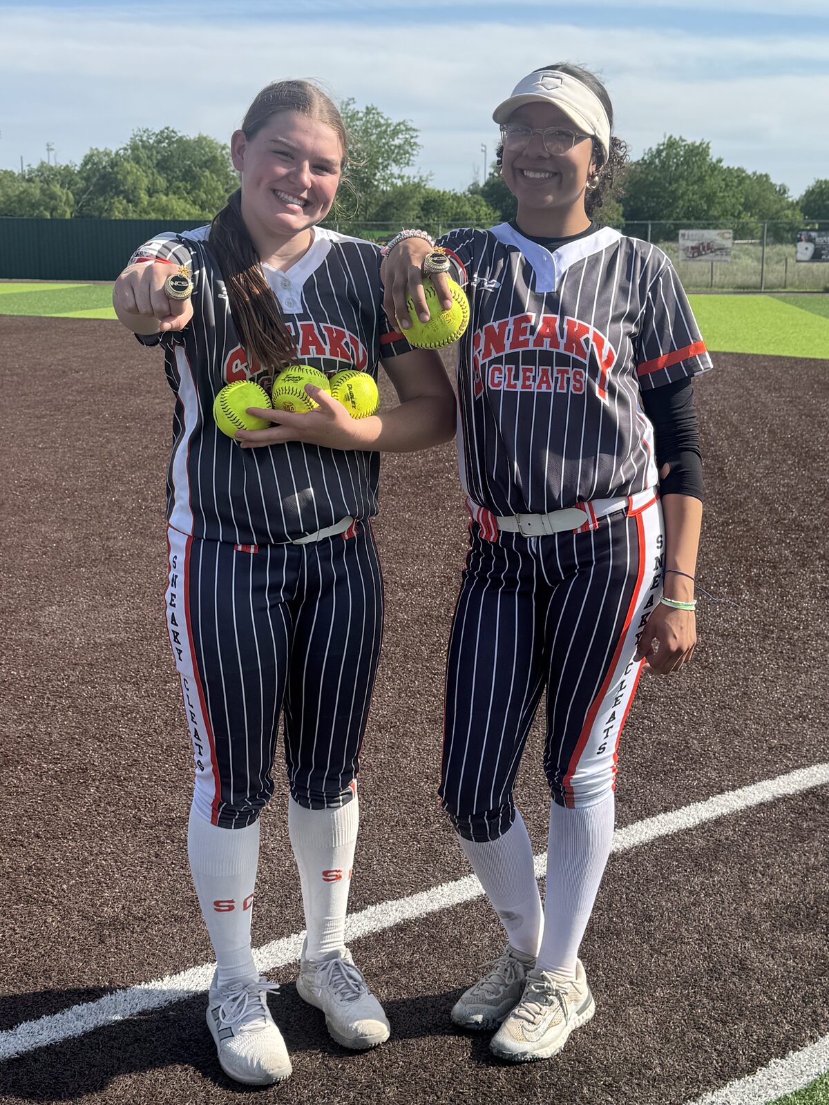 Adeline Camden with a teammate holding home run balls